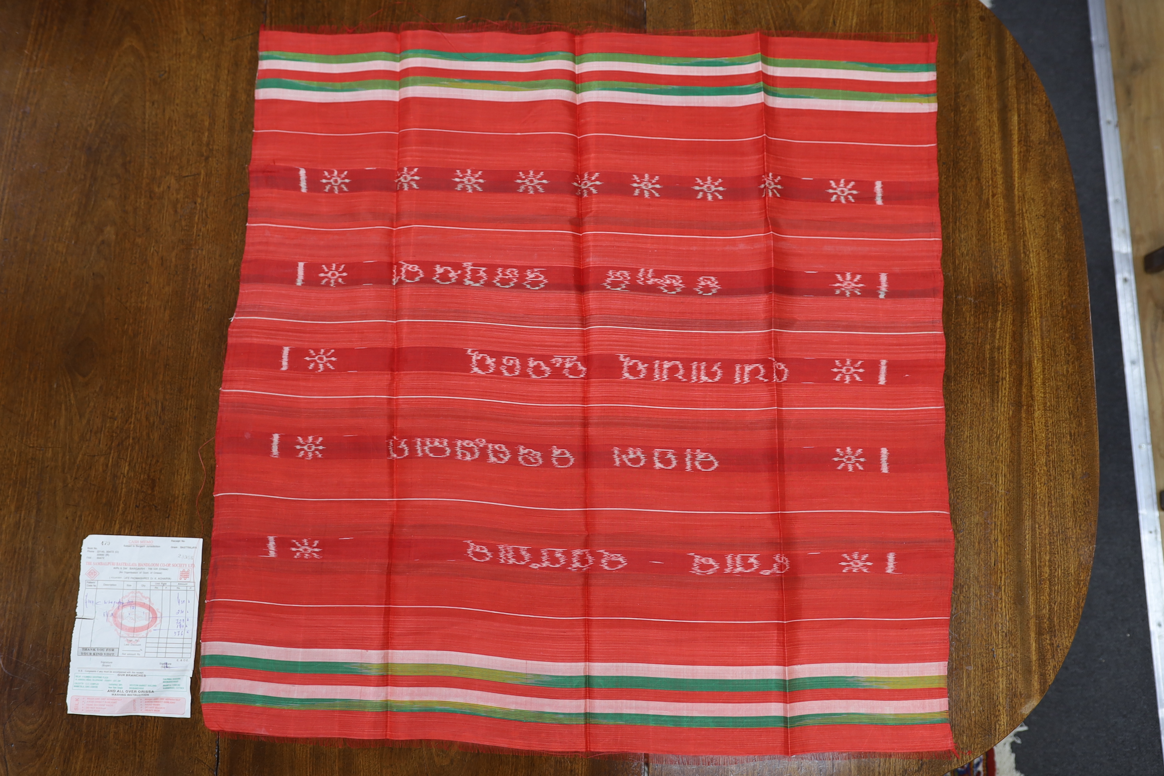 An Indian silk woven cloth, possibly a temple cloth, from Orissa, printed on the warp, with original receipt and paper bag